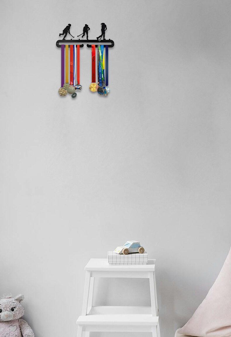 Tyttöjen salibandy-aiheinen teräksinen mitalihenkari, jossa kolme pelaajahahmoa ja poninhännät.